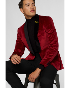 Red velvet dinner jacket worn by man sitting on stool